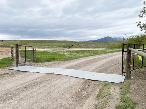 Drive-over electric mat, two metal plates across and gate crossing of a gravel road