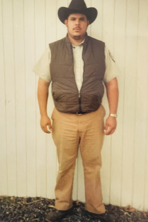 FWS employee Robert Luna as a young man. He's wearing a black cowboy hat, vest, and FWS uniform.