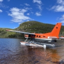 airplane floating on water with mountains in the background