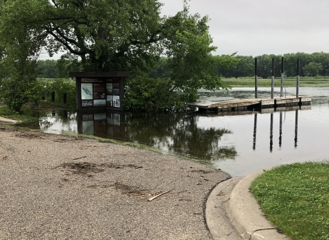 The Mississippi River backwaters cover the pavement of a refuge boat landing, making the boat ramp inaccessible to vehicle traffic